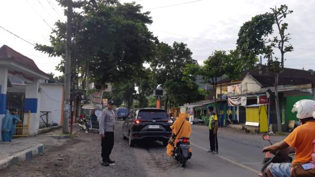 Jaga Keselamatan Siswa, Anggota Polsek Pasirian Bantu Anak Sekolah Menyeberang Jalan